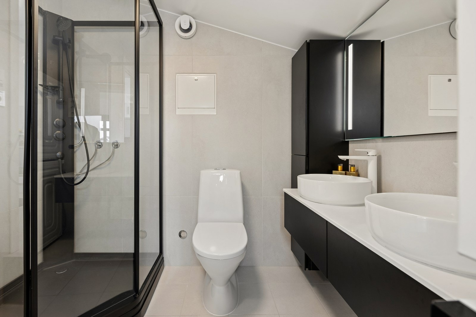 Badet er utstyrt med dusjkabinett, toalett, opplegg for vaskemaskin/tørketrommel og en moderne baderomsinnredning. Galleribilde