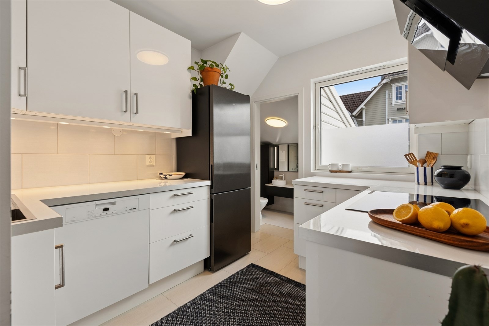 Kjøkkenet er stilrent og moderne. Innredning med hvite slette fronter og benkeplate av typen laminat. Galleribilde