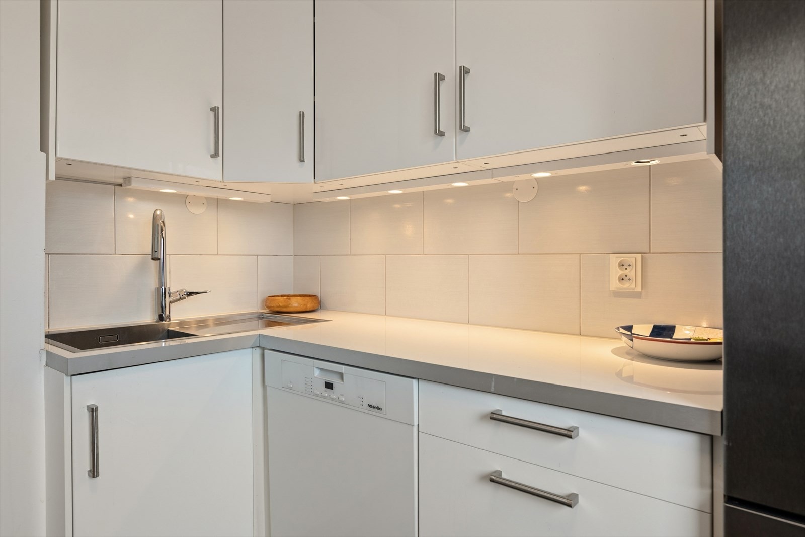 I innredningen er det integrerte hvitevarer som stekeovn og platetopp, samt plass for frittstående oppvaskmaskin og kjøl/frys. Galleribilde