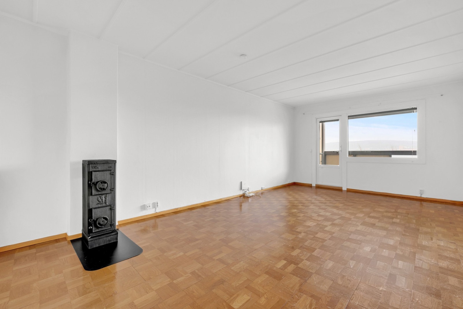 Leiligheten byr på to romslige soverom, et separat kjøkken, et pent baderom fra 2018, en lys stue med vedovn, walk-in closet og en stor, innglasset balkong. Galleribilde