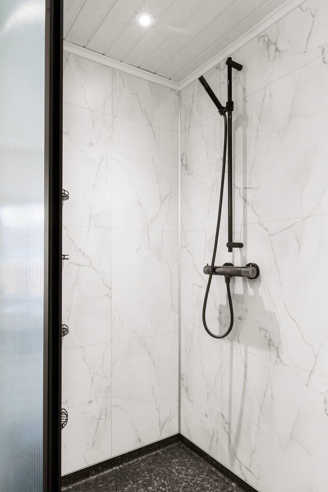Dusjsonen har nye baderomsplater fra 2023, og det er opplegg for vaskemaskin på badet. Galleribilde