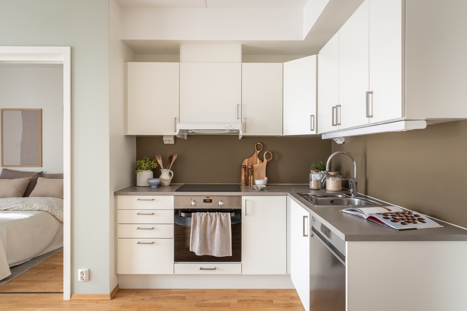Delvis integrerte hvitevarer med Bosch platetopp og Zanussi stekeovn. Under benk er det plassert oppvaskmaskin og det er plass til frittstående kjøle-/fryseskap. Galleribilde
