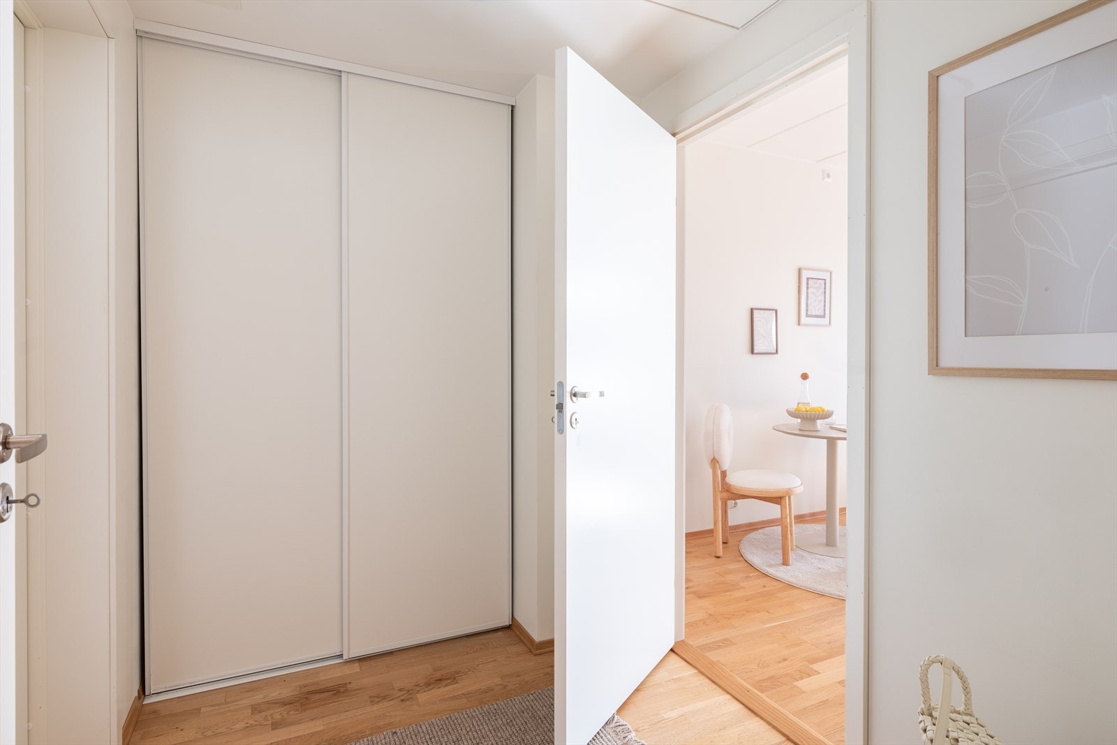 Entreen gir et pent førsteinntrykk av leiligheten, innredet med parkett på gulv og lyse vegger, noe som er gjennomgående for øvrige oppholdsrom. Det er skyvedørsgarderobe til oppbevaring. Galleribilde