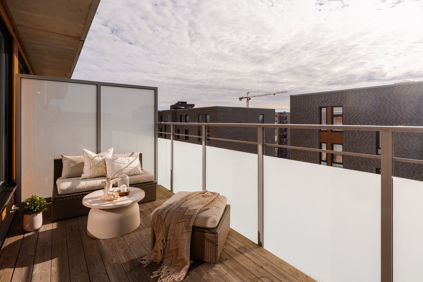 Dekket er utført med terrassegulv i impregnert treverk over betong, og rekkverk samt skillevegger i aluminium og frostet glass gir et moderne uttrykk samtidig som det skjermer godt. Galleribilde