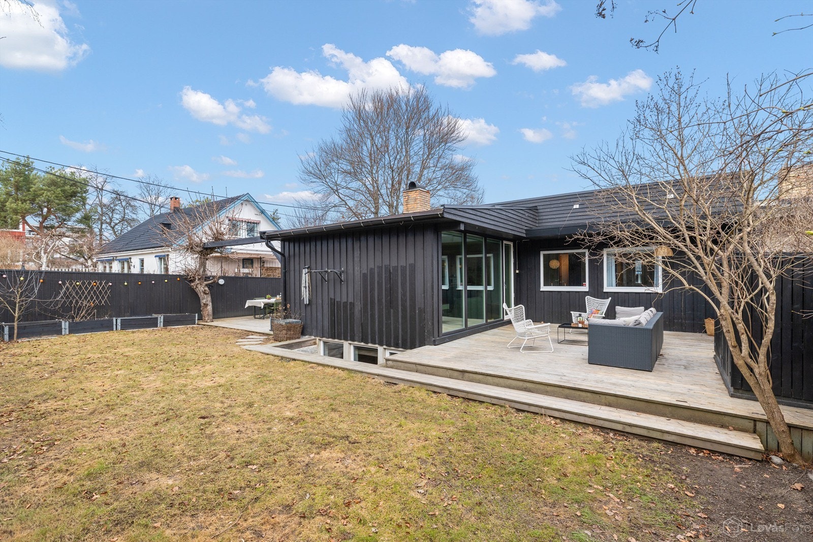 Solrik og meget pent opparbeidet tomt med flatt plenareal som knytter de to store markterrassene fint sammen Galleribilde