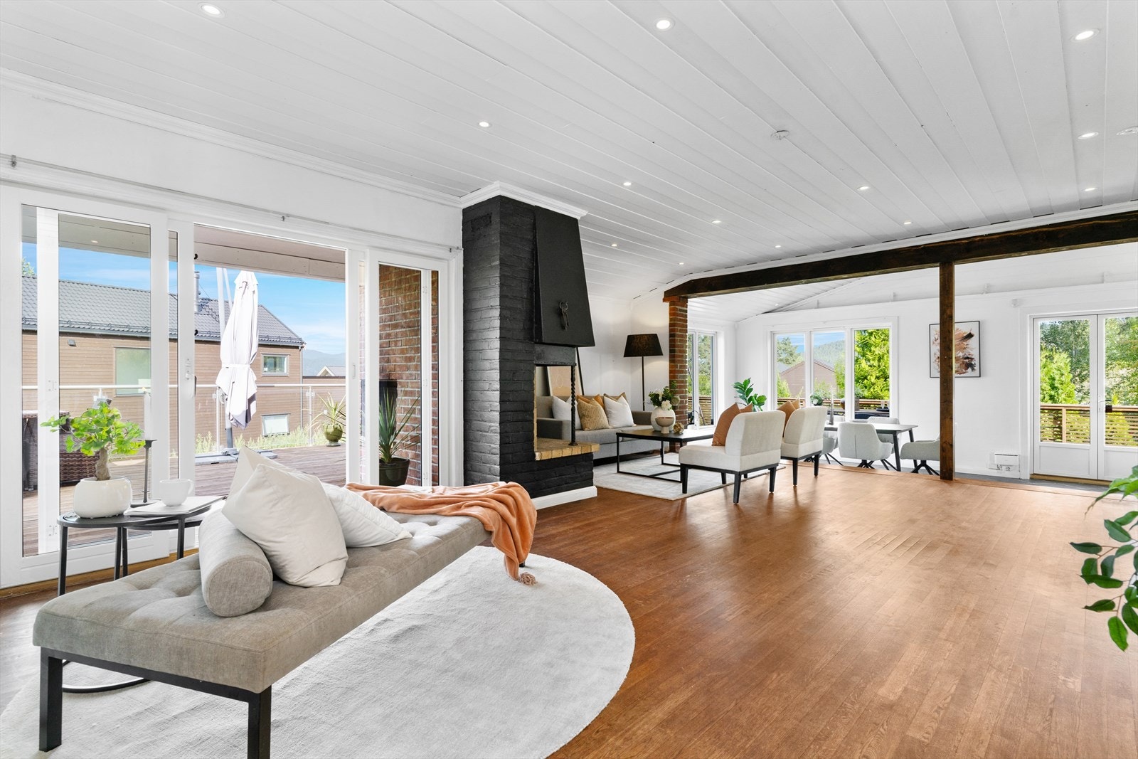 Romslig stue med utgang til stor terrasse. I taket er det utstrakt bruk av downlights. Galleribilde