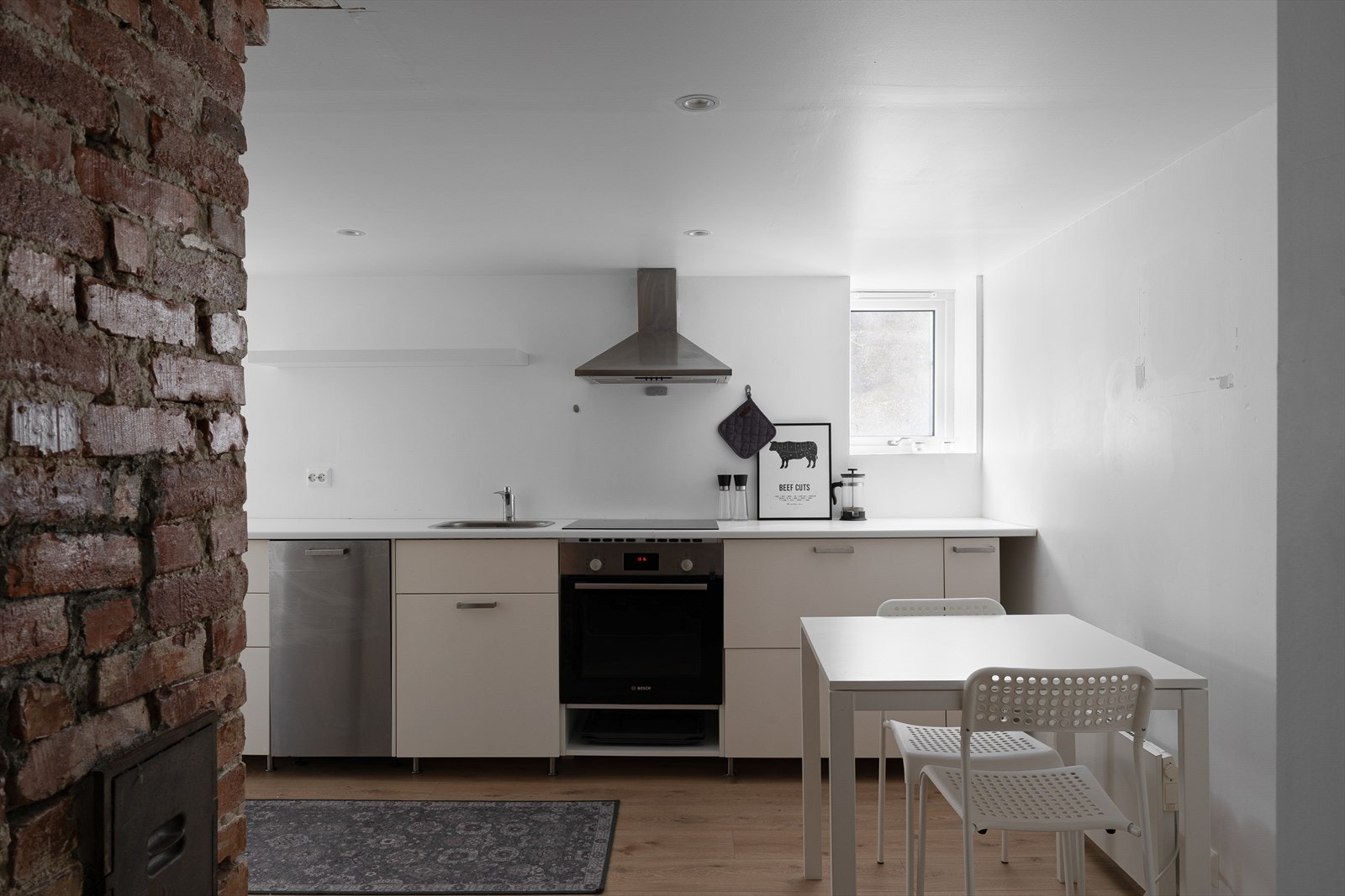 Romslig kjøkken med hvite fronter. Galleribilde