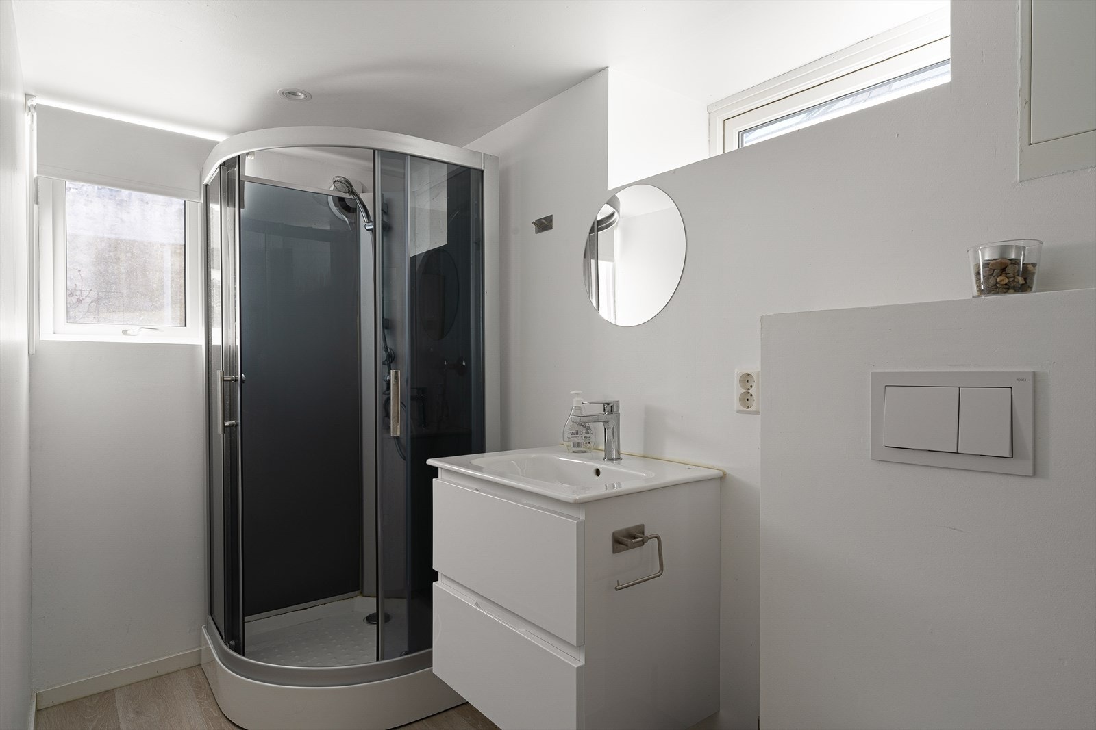 Bad i kjeller er innredet med dusjkabinett og veggmontert toalett. Galleribilde