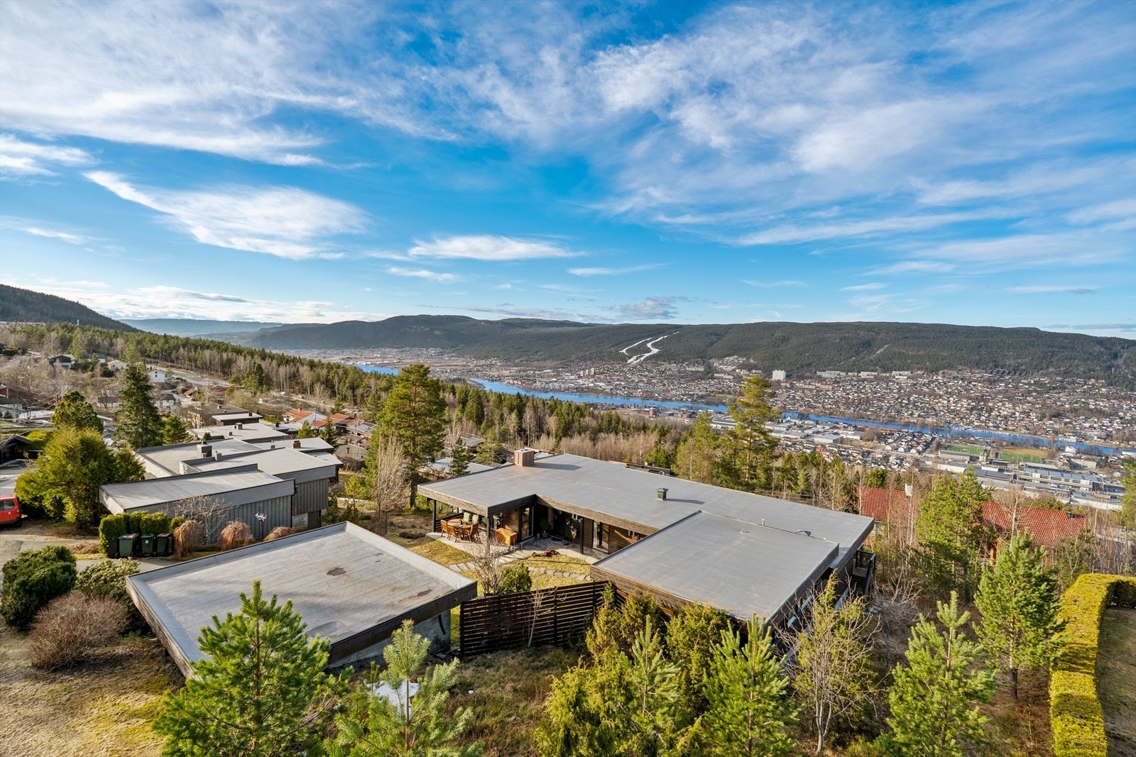 Terrenget er lett skrånende og har hellelagte gangsoner og gode uteplasser. Beliggenheten gir eiendommen gode lysforhold og svært attraktive utsiktsforhold over nærområdet. Galleribilde