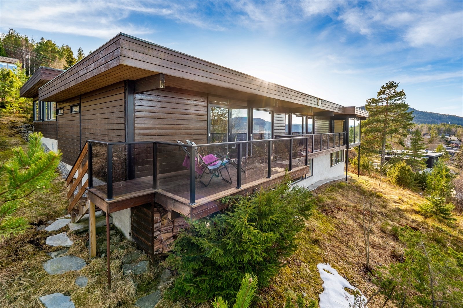 Den arkitekttegnede boligen er plassert slik at både terreng og omgivelser utnyttes optimalt, og de store vindusflatene gir en imponerende panoramautsikt. Galleribilde