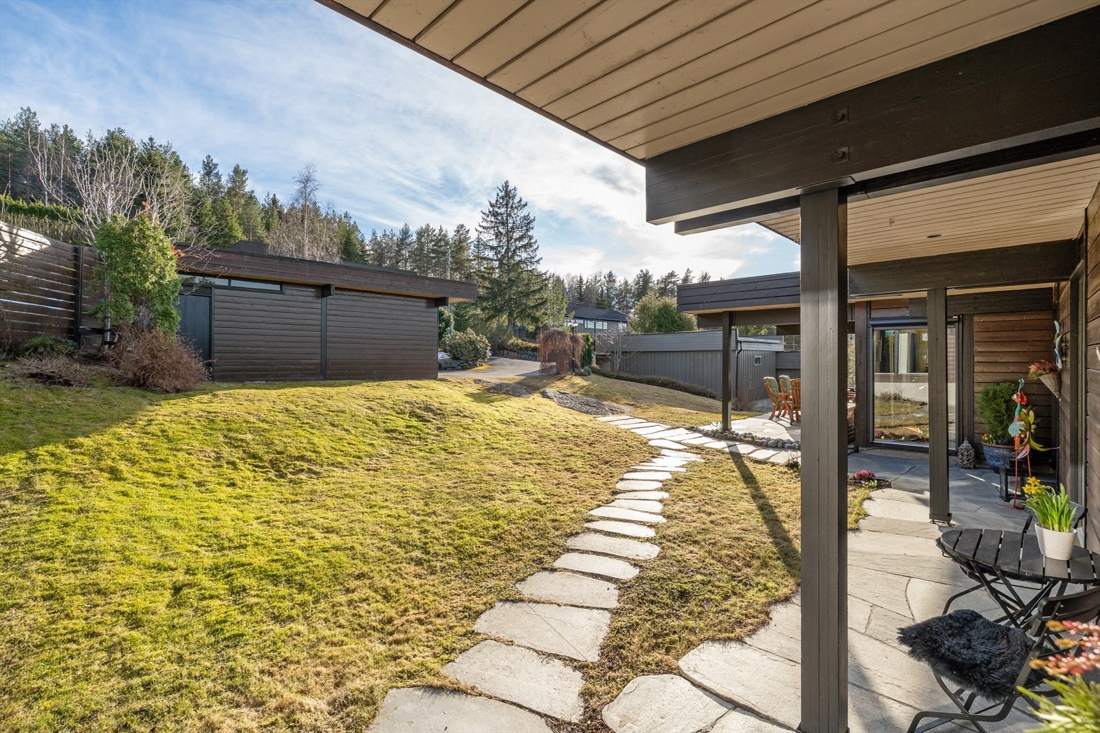 Tomten er pent opparbeidet med gressplen, prydbusker og ulike beplantninger som omkranser utearealene. Galleribilde