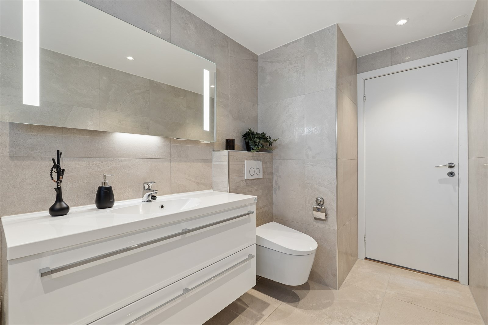 Baderommet fra 2015 fremstår moderne og velutstyrt - gulvet er flislagt og utstyrt med elektriske varmekabler. Galleribilde