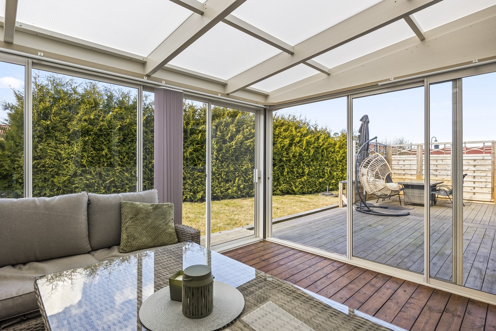 Innglasset terrasse med skyvedører mot hagen, som gir et lyst og anvendelig uterom. Galleribilde