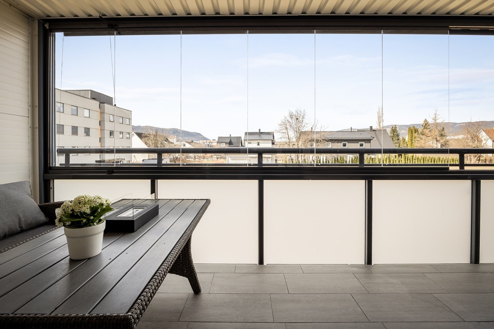 Uteplassen har glassvinduer som kan skyves helt opp når det er fint vær, og lukkes igjen når man ønsker mer skjerming. Galleribilde