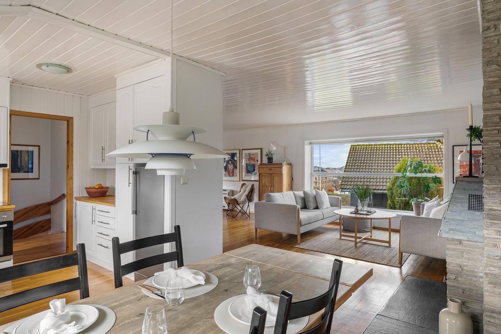 Utsyn fra spiseplassen mot stuen understreker den åpne og sosiale atmosfæren. Galleribilde