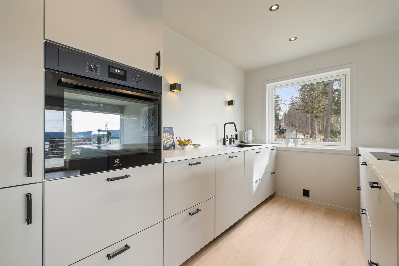 Kjøkkenet er utstyrt med hvitevarer som inkluderer stekeovn, oppvaskmaskin og induksjonstopp med innebygget ventilator. Galleribilde