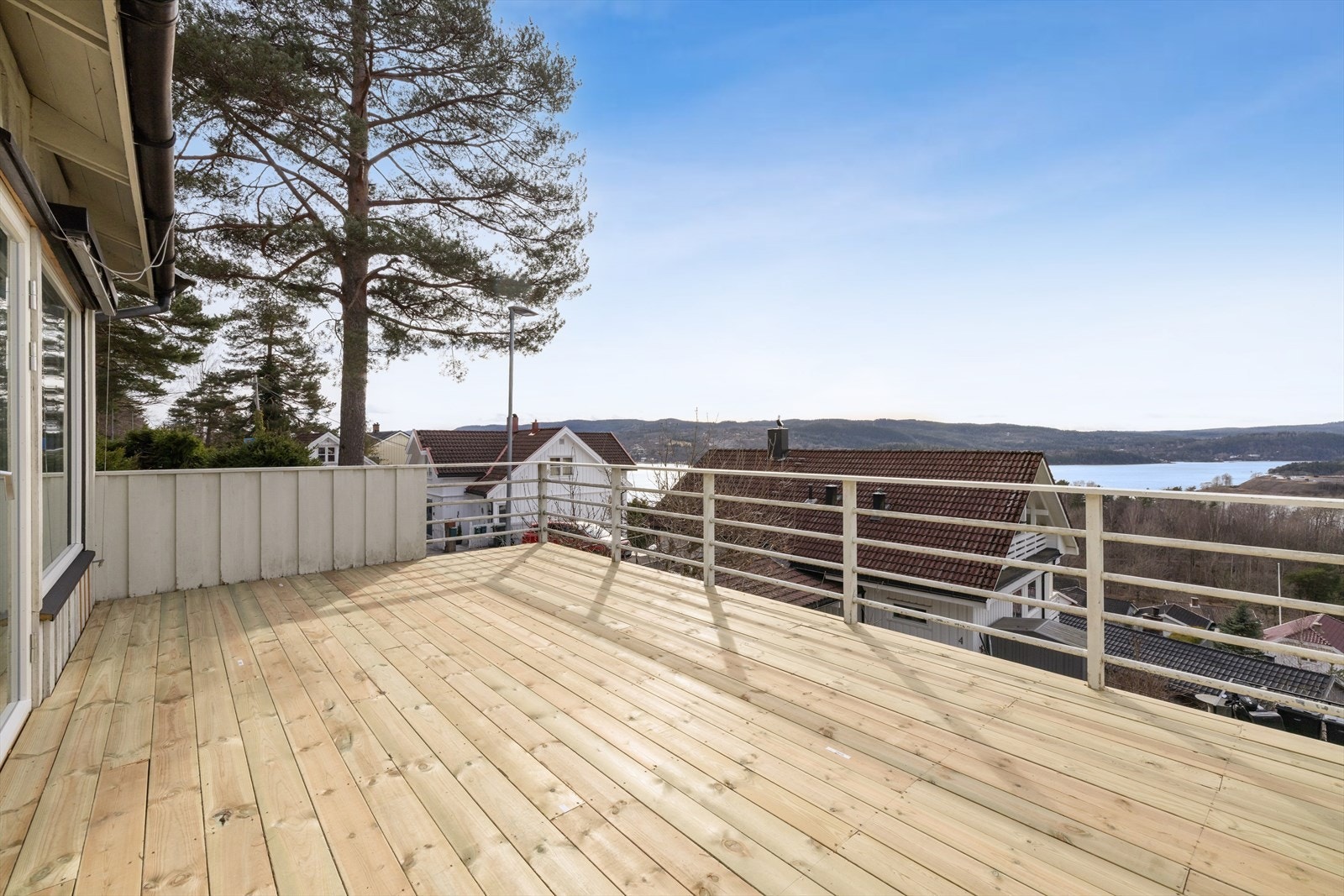 Den vestvendte takterrassen på ca. 20 m² har nytt, impregnert tregulv og en fantastisk utsikt over fjorden. Galleribilde