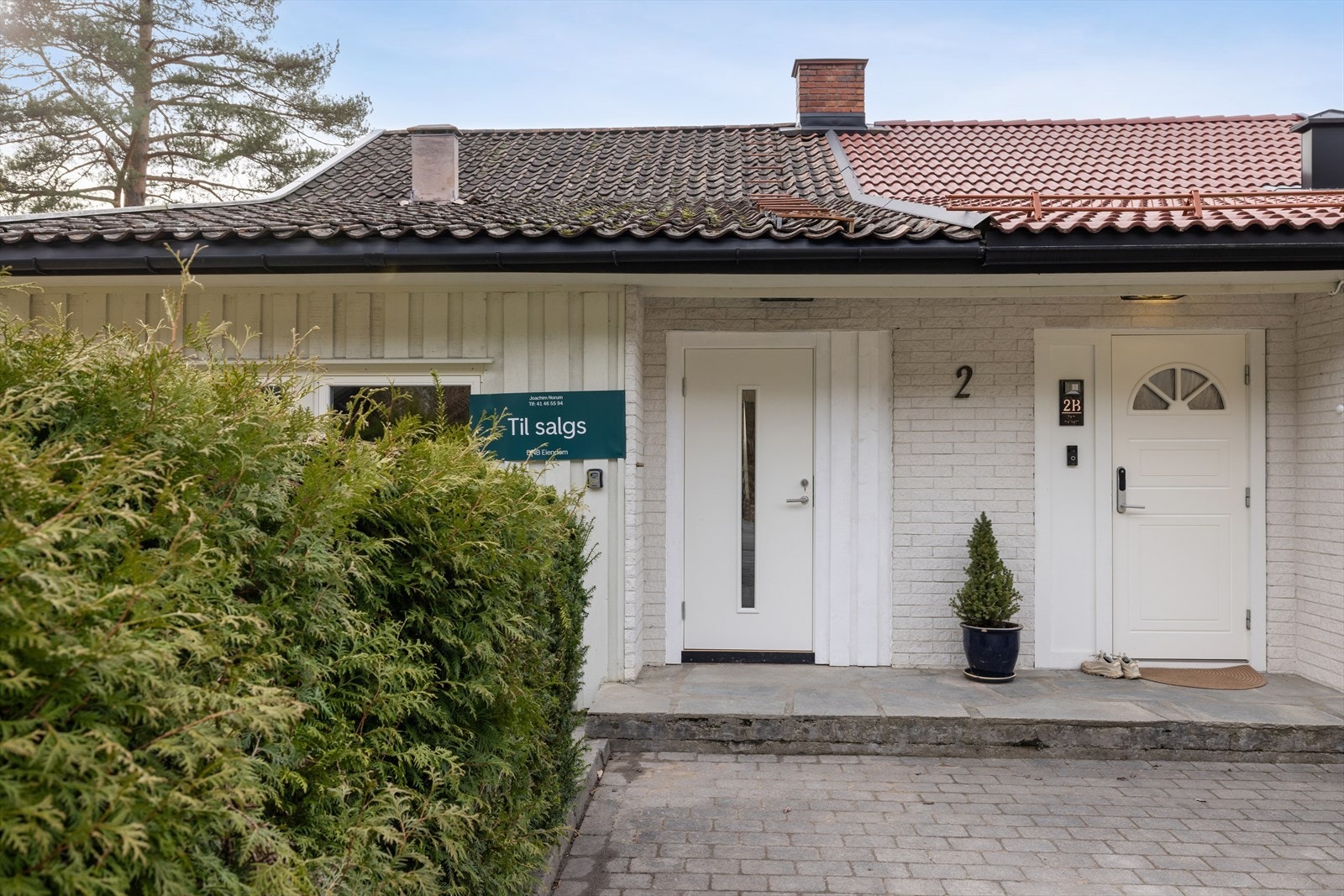 Pent inngangsparti med steinbelagt gårdsplass. Galleribilde
