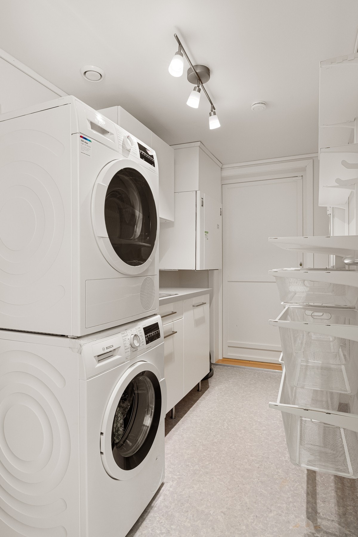 Praktisk vaskerom med innredning med vask, hylleløsing og utgang til terrasse Galleribilde