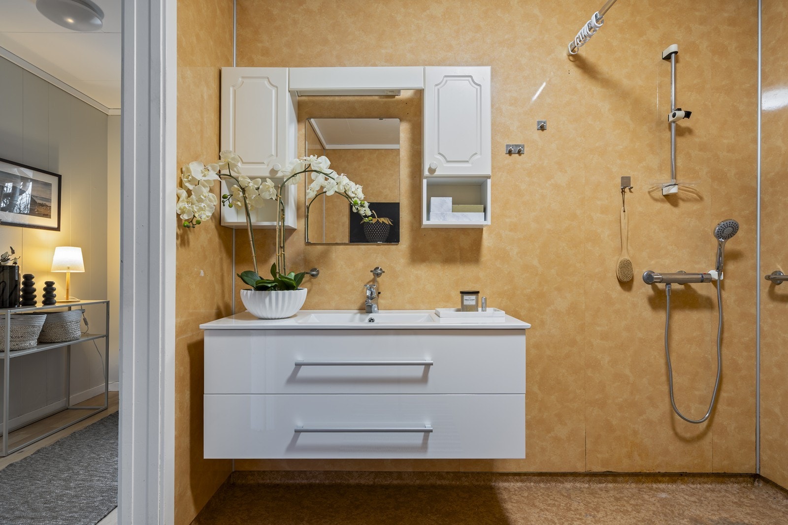 Badet har dusj, seksjon med vask, veggmontert toalett og opplegg for vaskemaskin Galleribilde