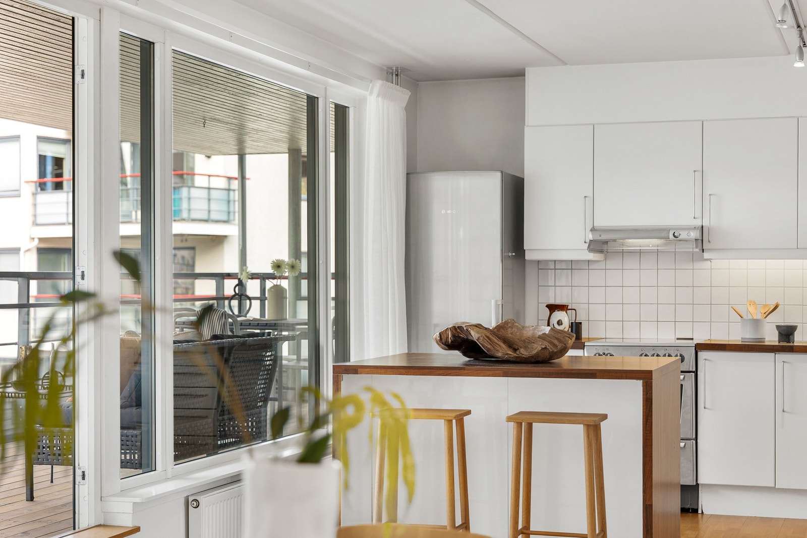 Kjøkkenøy med utstikker for sitteplass med barstoler. Galleribilde