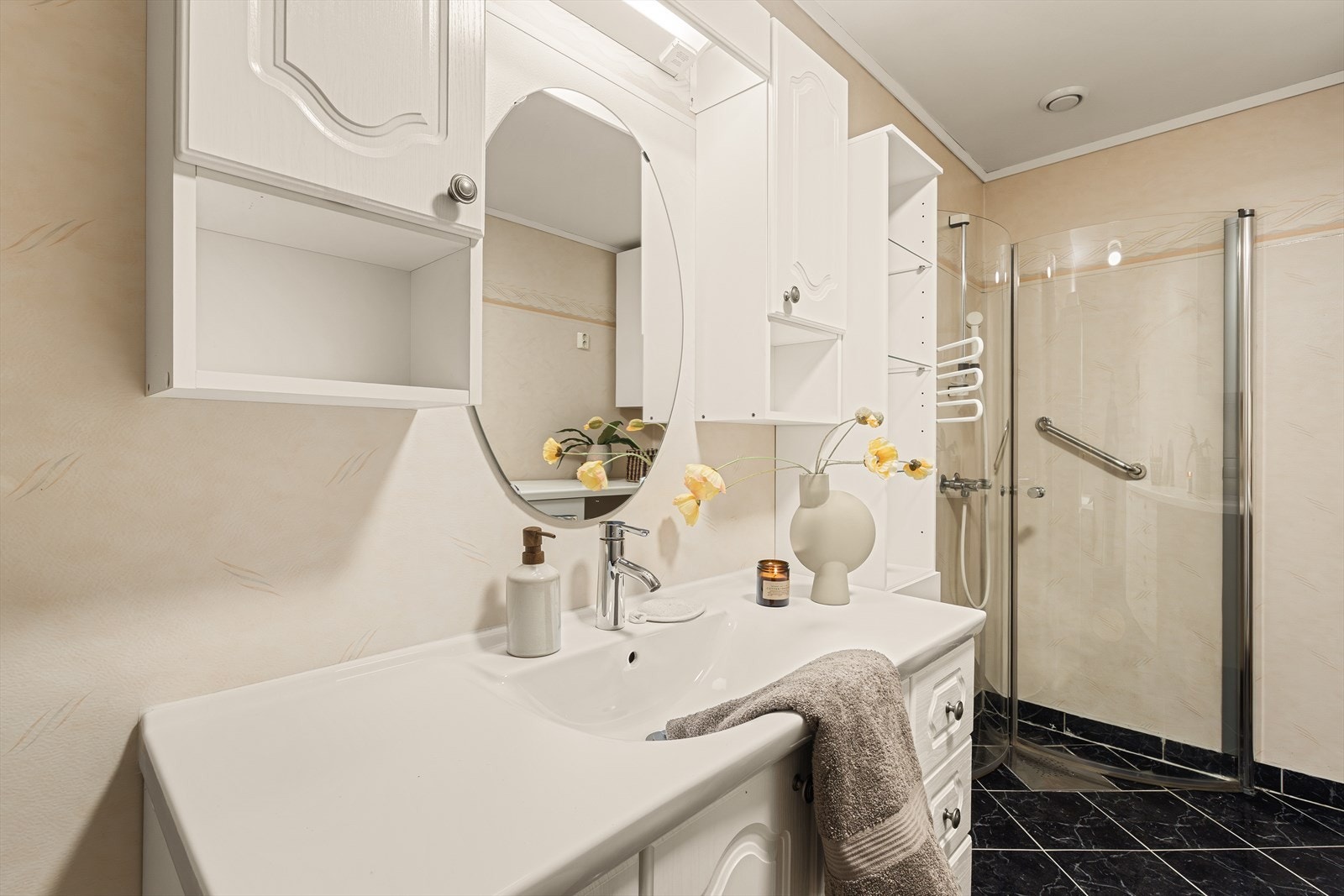 Badet er innredet med baderomsinnredning med hvite profilerte fronter, heldekkende servant, under- og overskap samt speil. Galleribilde