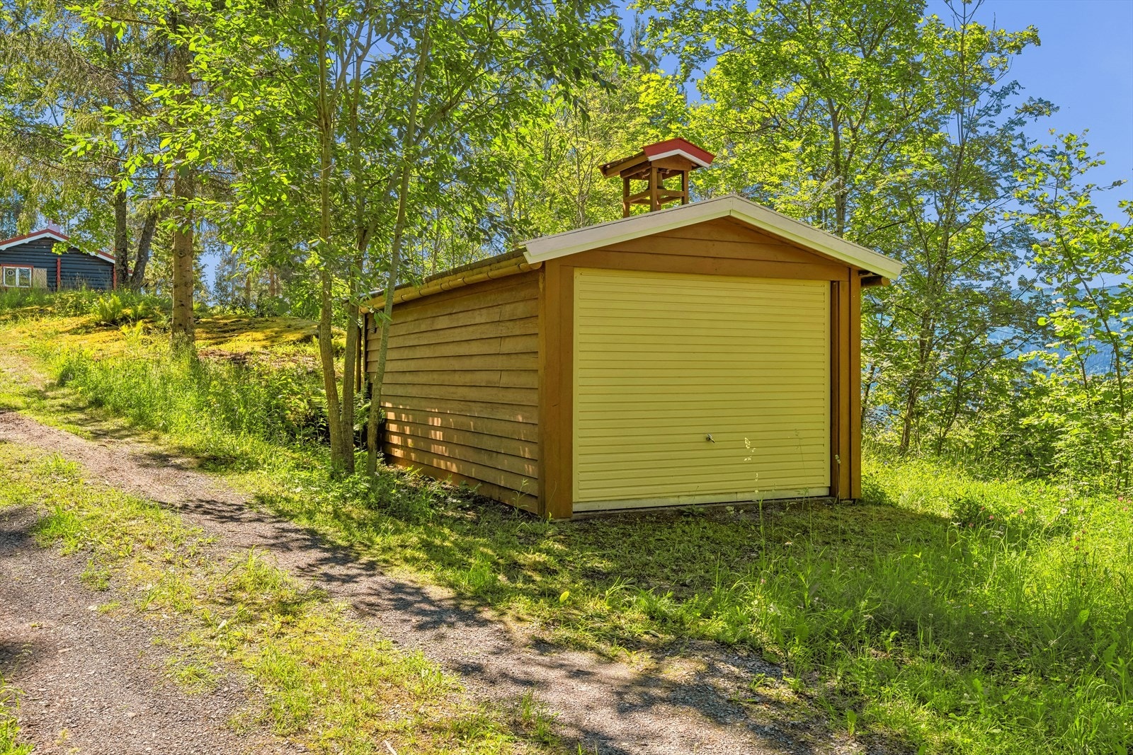 I tillegg til parkering for flere biler på egen tomt ved fritidsboligen, er det også en garasje på 18 kvm. Galleribilde