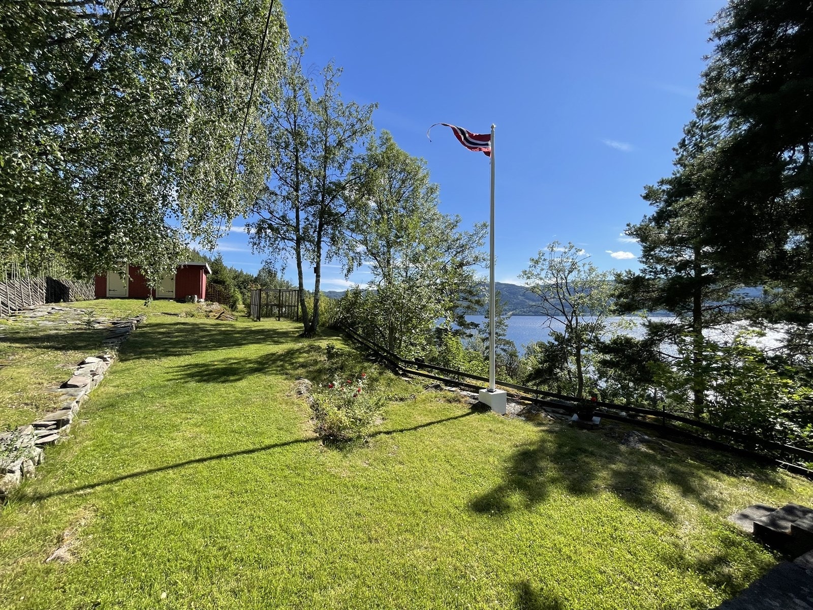 Romslig gårdsplass med et uthus til hageredskap og utedo på baksiden av hytta... Galleribilde
