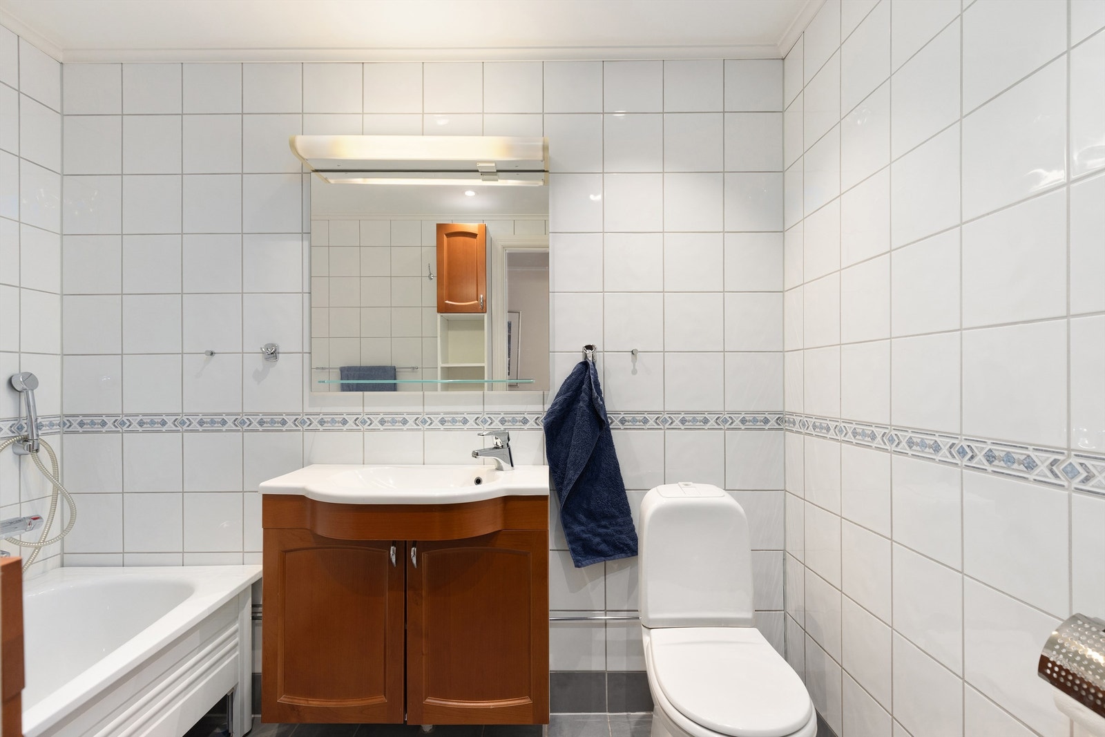 Badet er videre utstyrt med gulvstående WC og godt med oppbevaring i servantskap og veggskap Galleribilde
