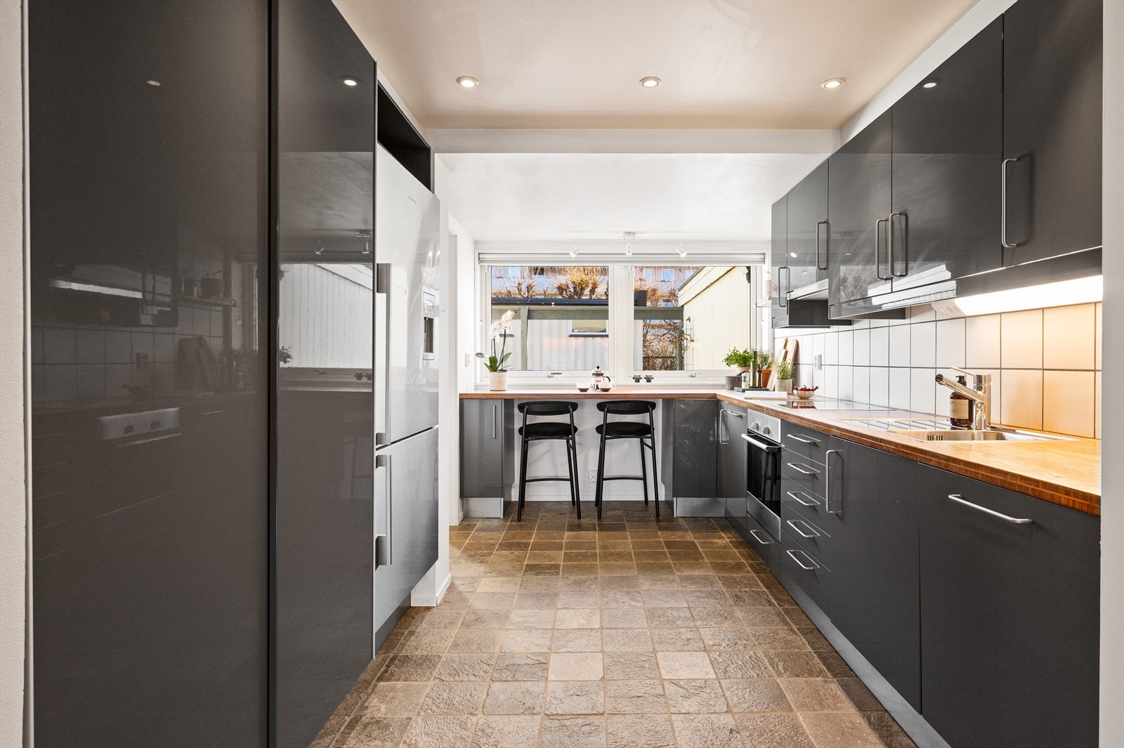 Innredningen har glatte fronter og en benkeplate i bambus med kjøkkenkran og nedfelt kum i rustfritt stål. Galleribilde