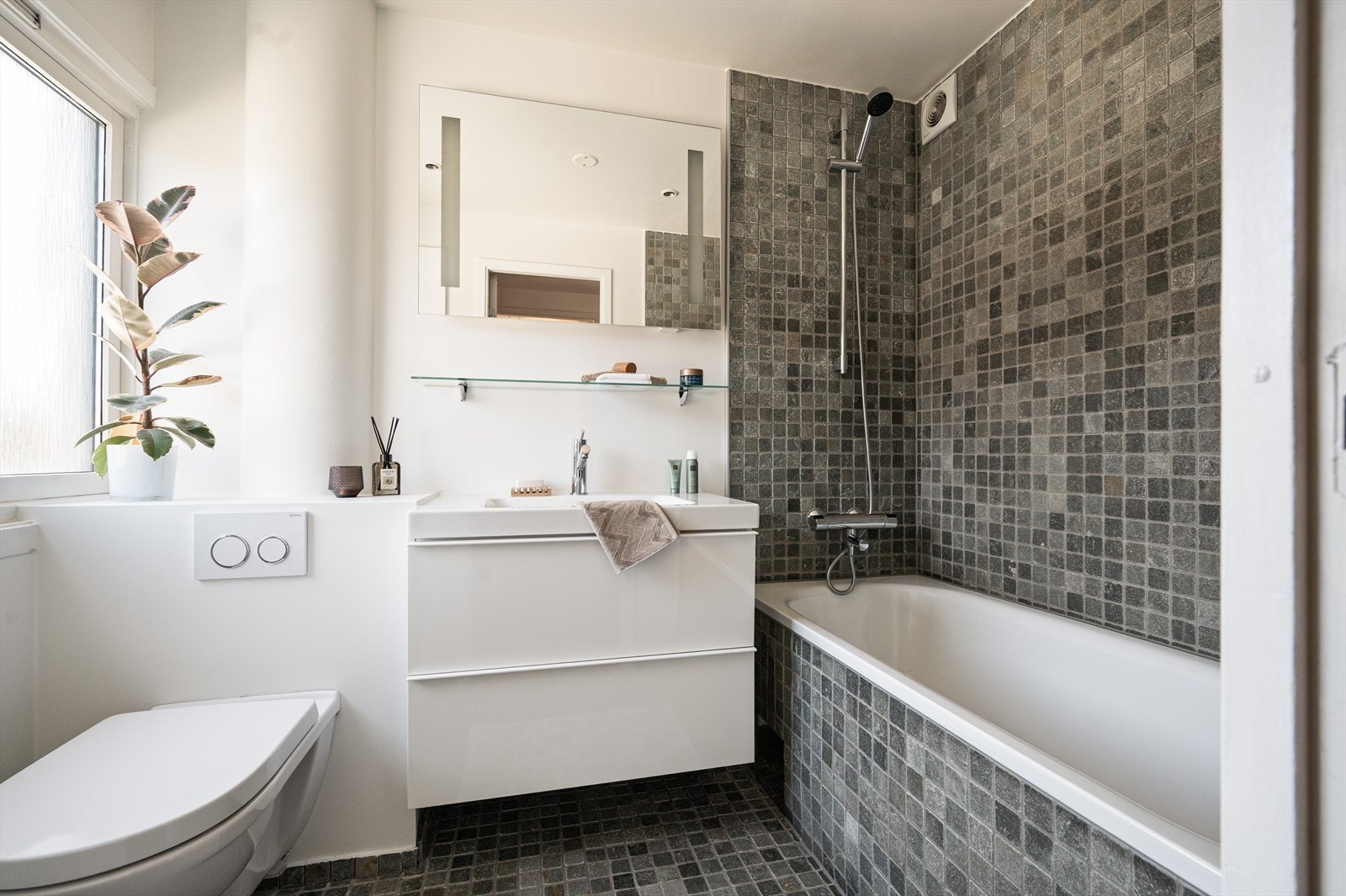 Baderommet i andre etasje har fliser på gulvet og kombinasjon av fliser og malte overflater på veggene. Galleribilde