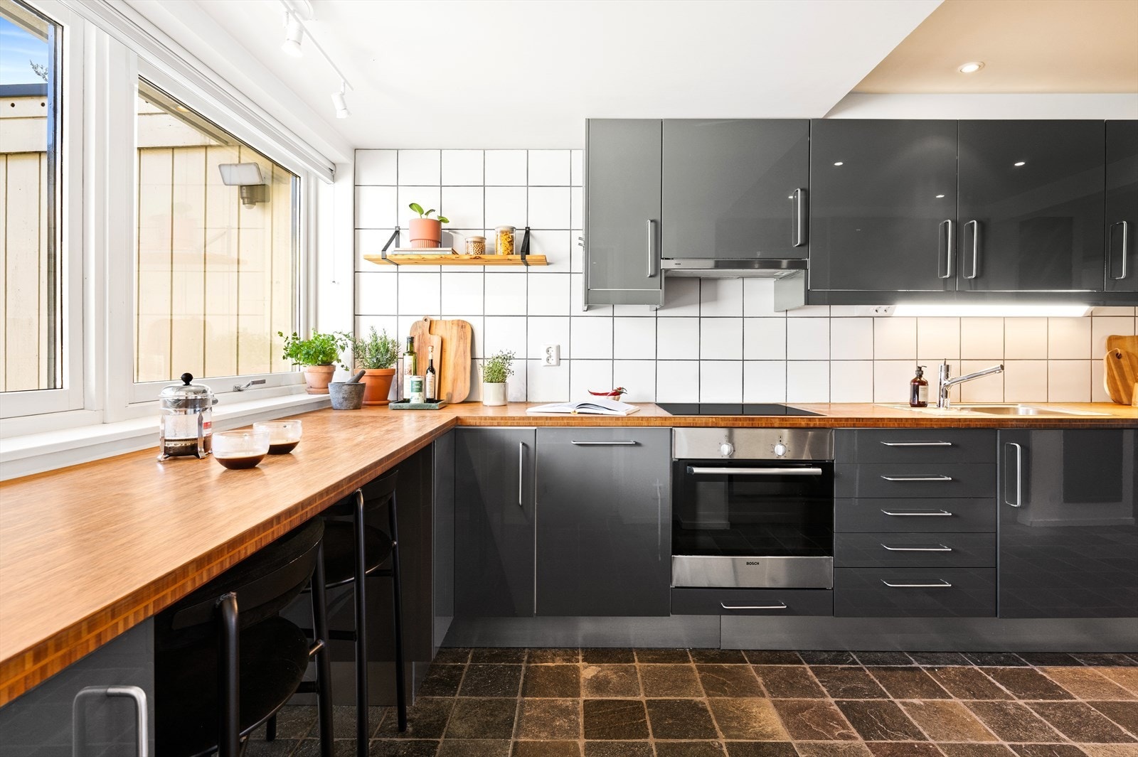 Videre tar vi turen inn til kjøkkenet, som ligger praktisk til i tilknytning til oppholdsrommet. Her finner vi en velholdt IKEA-kjøkkeninnredning fra 2010, utført i et tidløst uttrykk som passer godt inn i boligens helhet. Galleribilde