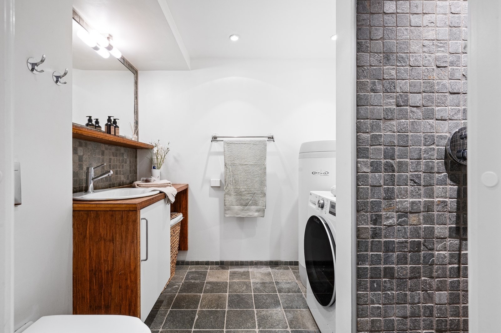 Badet i første etasje har fliser på gulvet, samt en kombinasjon av fliser og malte overflater på veggene. Behagelig gulvvarme og downlights i himling. Galleribilde