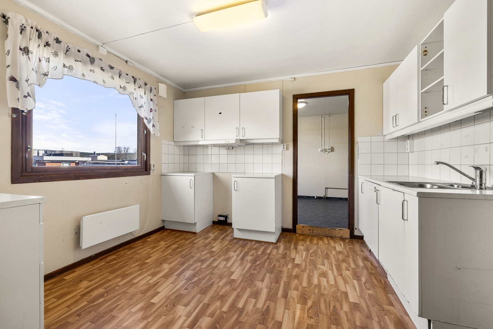 Kjøkkenet har en praktisk innredning med glatte fronter og laminat benkeplate. Galleribilde