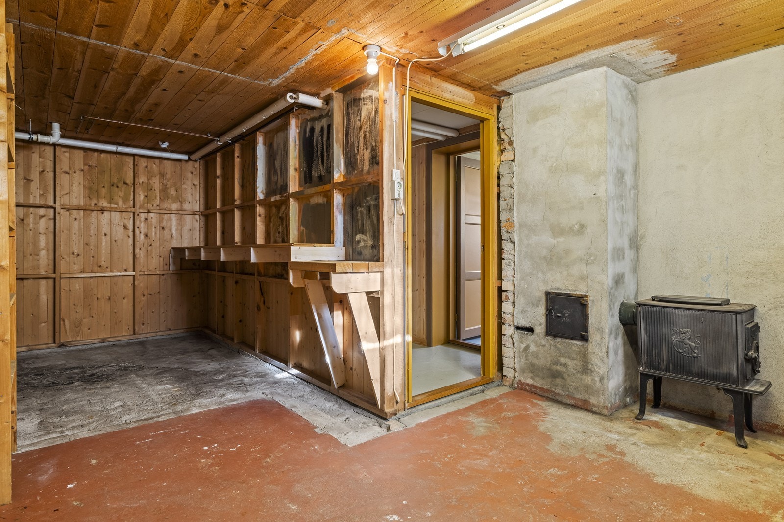 Kjelleren har støpt betonggulv og vegger av betong/mur. Sotluken til pipen er plassert i en av bodene. Galleribilde