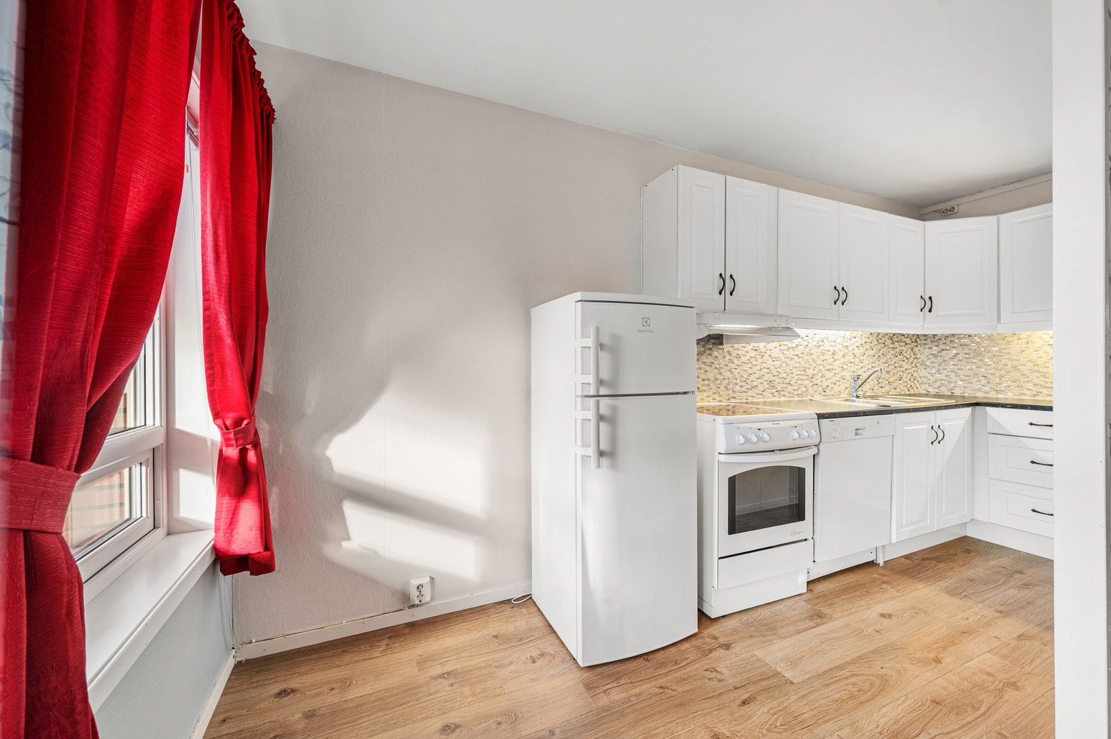 Kjøkken med over- og underskap for oppbevaring. Kjøkkenet er på 7,4m² med et praktisk skille mellom stue og kjøkken. Galleribilde