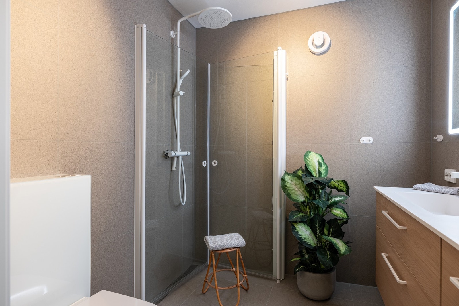 Badet er flislagt med store, delikate fliser og har en behagelig gulvvarme gjennom varmekabler. Fint dusjhjørne med regnfallsdusj. Galleribilde