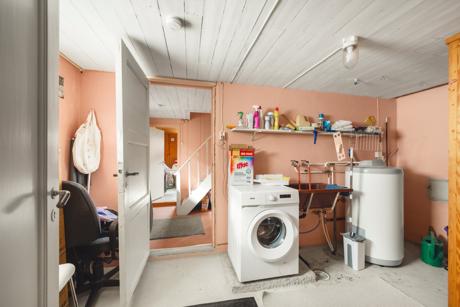Vaskerom med vaskemaskin, varmtvannsbereder og hyller til oppbevaring. Galleribilde