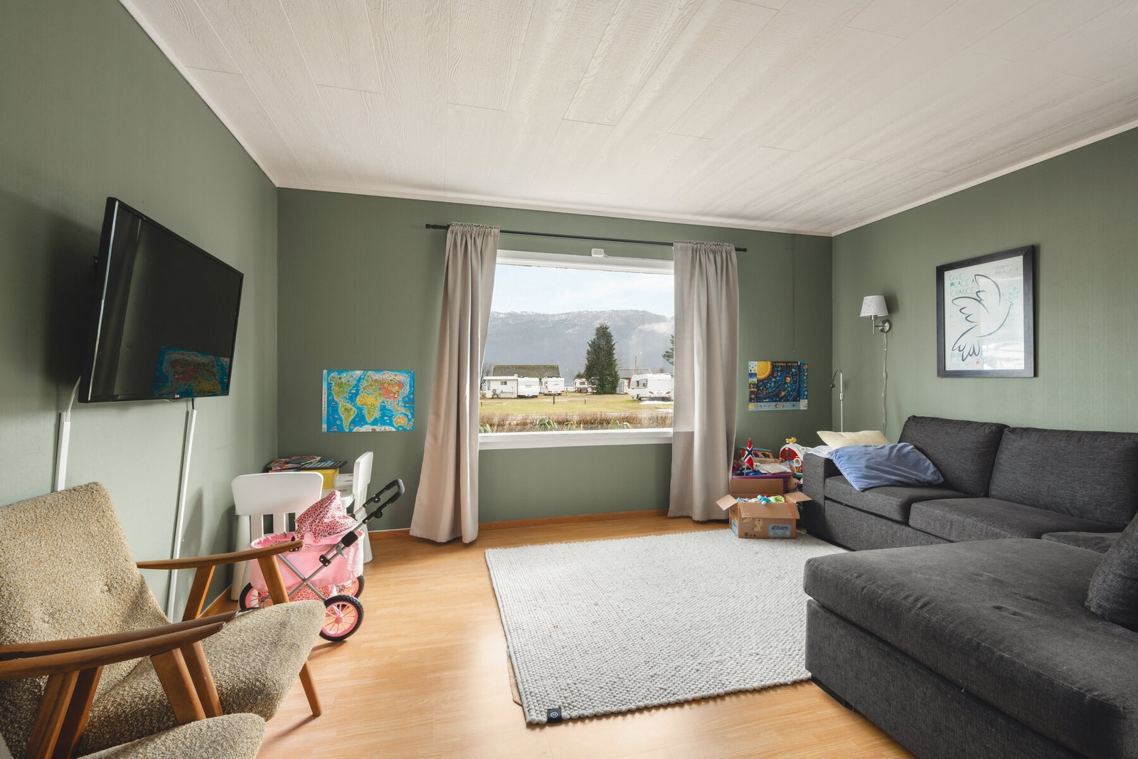 Stue med store vinduer som gir godt lysinnslipp og utsikt mot fjell og natur. Galleribilde