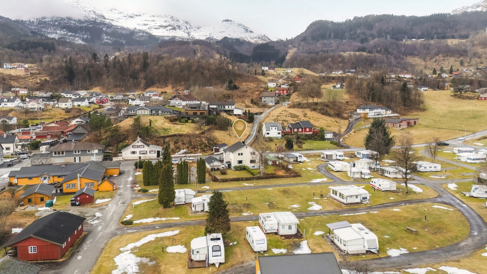 Bolig i naturskjønne omgivelser med utsikt over nærliggende bebyggelse og fjell. Galleribilde