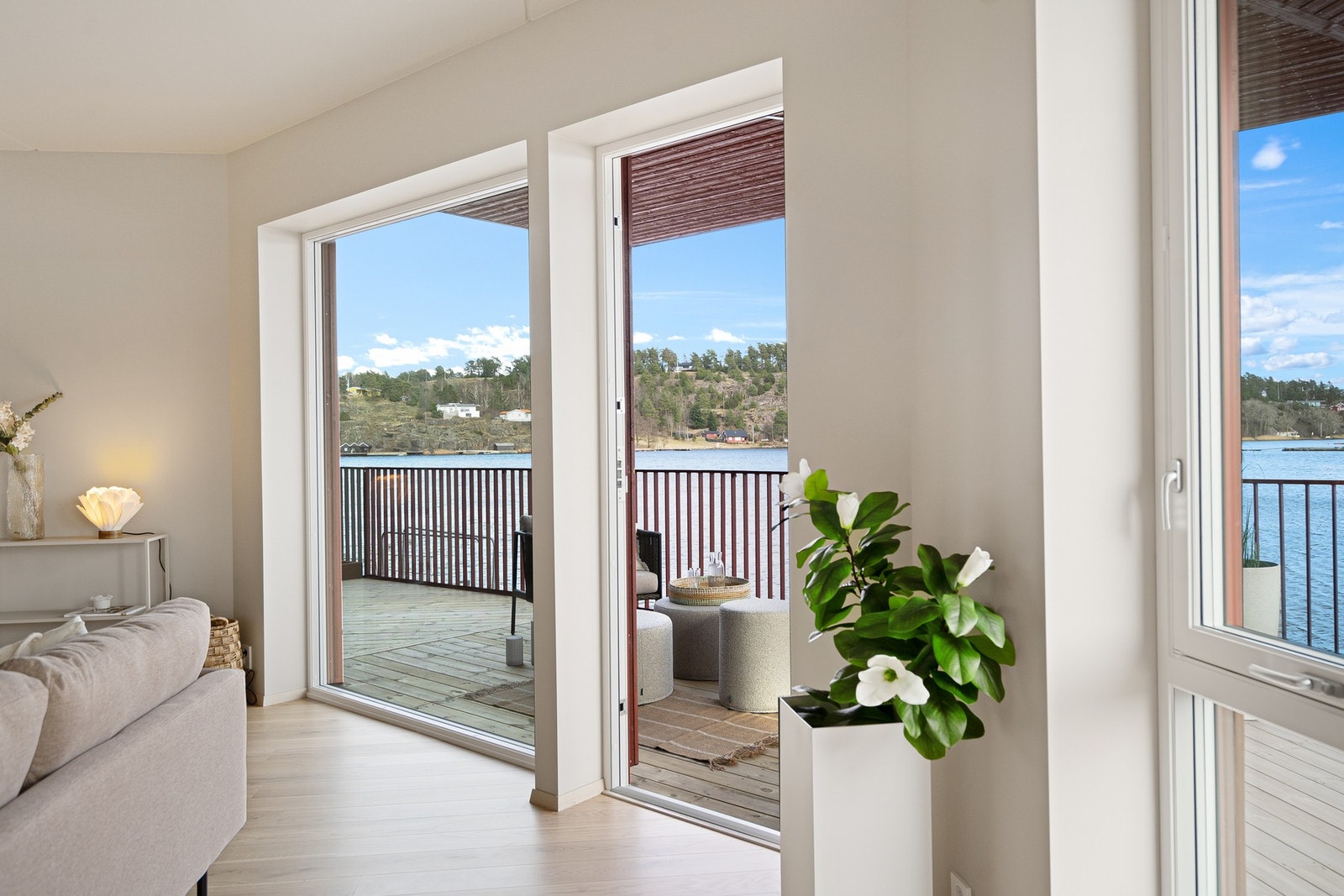 Utgang til meget solrik terrasse som grenser til sjøen Galleribilde