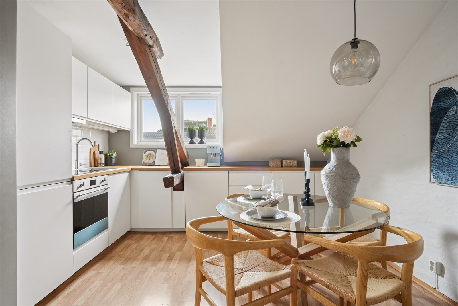 Kjøkkenet har hvite, glatte fronter som harmonerer godt med boligens lyse uttrykk. Galleribilde