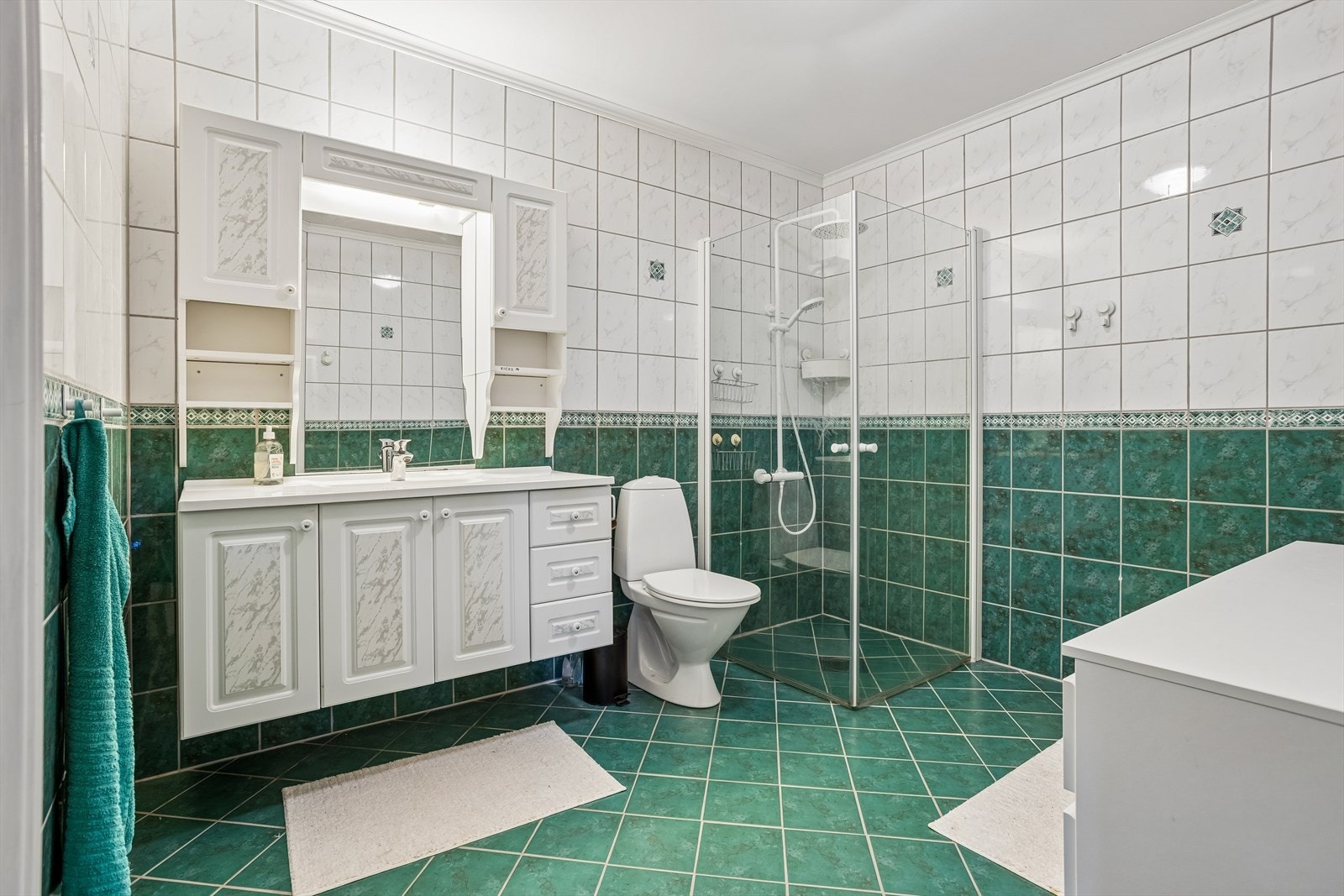 Badet i underetasjen har varmekabler i gulvet og vendbare dusjdører i glass. Galleribilde