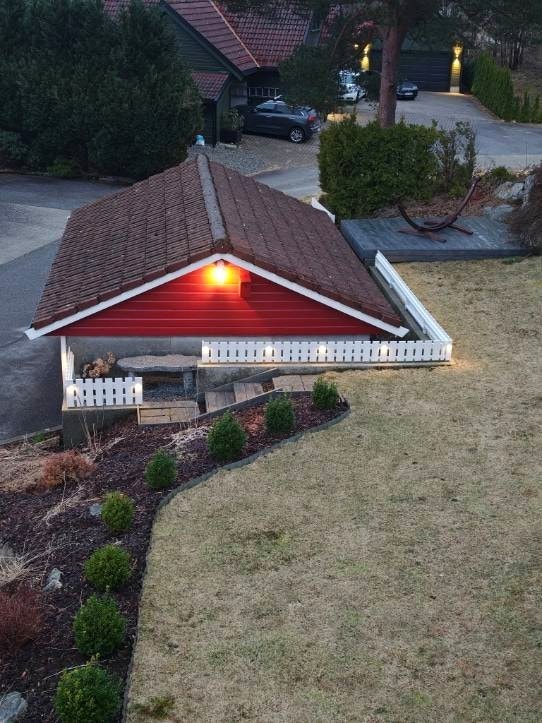 Til eiendommen hører en frittstående garasje med elektrisk port og en tilhørende platting på ca. 8 m². Galleribilde