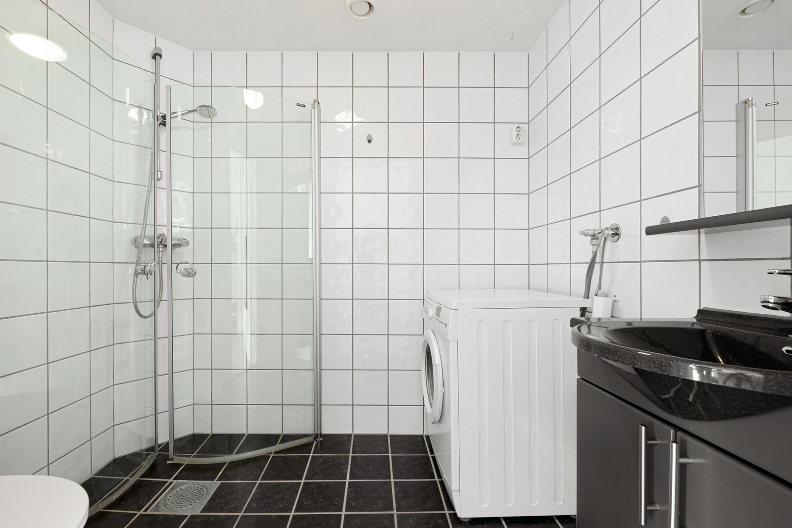 Moderne og praktisk bad med stilrent dusjhjørne. Opplegg for vaskemaskin for enkel hverdag. Galleribilde