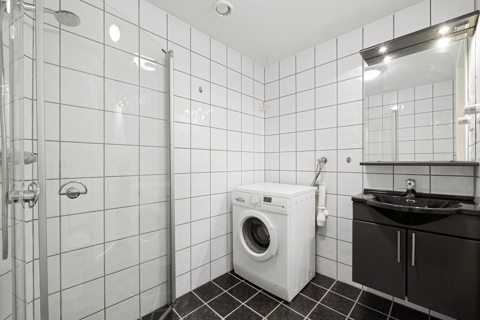 Rørskap sikrer ryddig installasjon. Elegant baderomsinnredning med servant, underskap og speil. Galleribilde