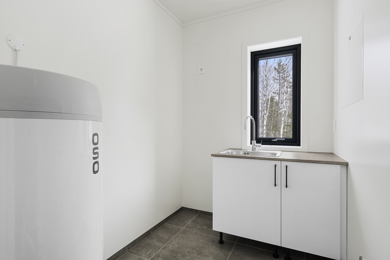 Praktisk og funksjonelt vaskerom med god plass til vaskemaskin og oppbevaring. Galleribilde