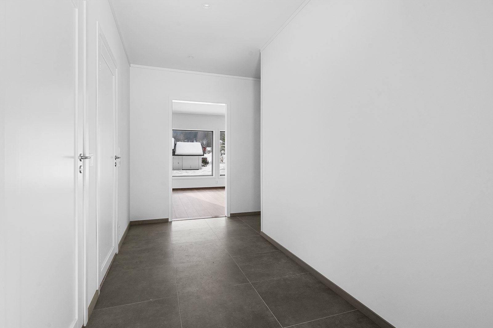 Fra overbygget inngangsparti kommer man inn i en lys og romslig entré med flislagt gulv og varmekabler som gir en komfortabel velkomst. Galleribilde