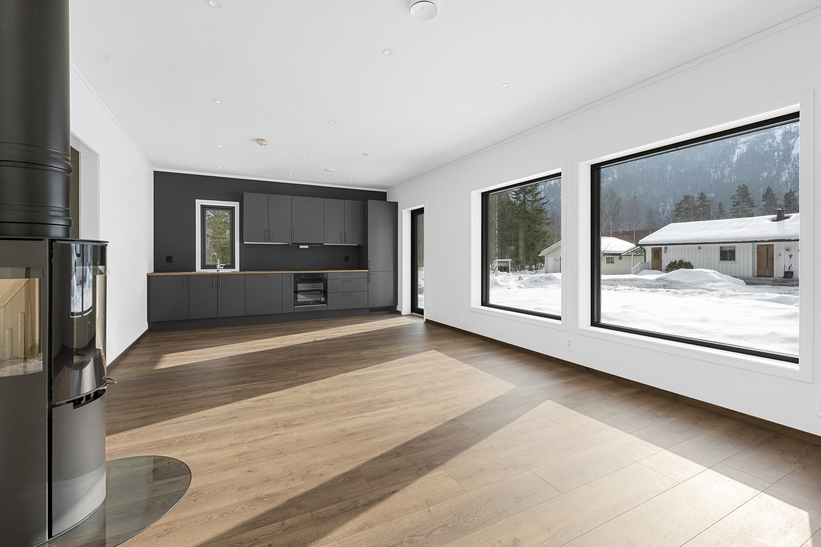 Stue og kjøkken ligger i en åpen og sosial løsning med store vindusflater som gir rikelig med naturlig lys og en luftig romfølelse. Galleribilde