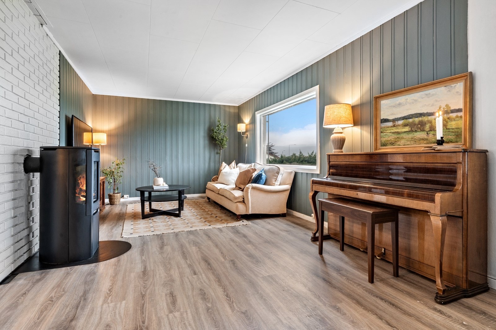 Stuen har laminat på gulv og malt panel på vegger Galleribilde